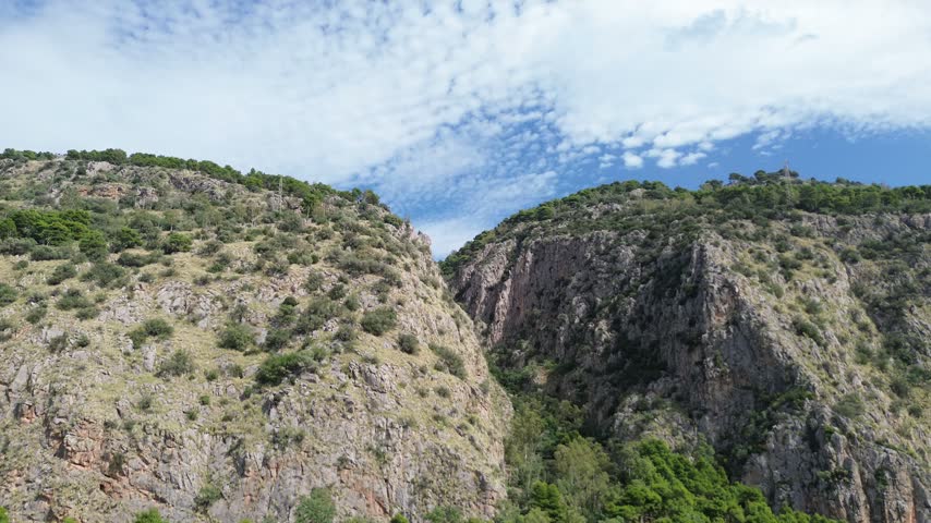 Aerial view of Monte Pellegrino above Palermo, Sicily, featuring limestone cliffs, Mediterranean vegetation and coastal landscape.