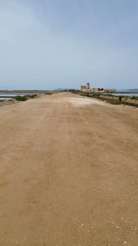 Aerial view of the salt pans and wetlands of Trapani and Paceco in Sicily, featuring geometric evaporation ponds and coastal scenery.