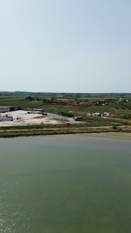 Aerial view of the salt pans and wetlands of Trapani and Paceco in Sicily, featuring geometric evaporation ponds and coastal scenery.