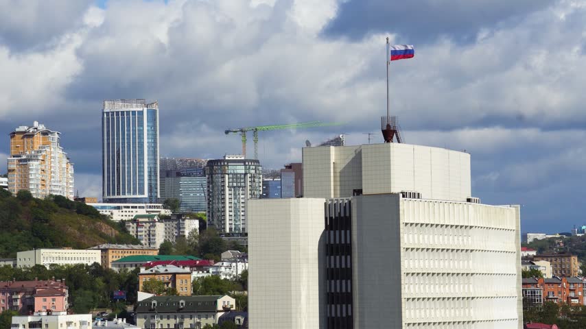 Russian flag atop the Primorsky Krai Government building in Vladivostok video, symbolizing regional administration and national identity.
