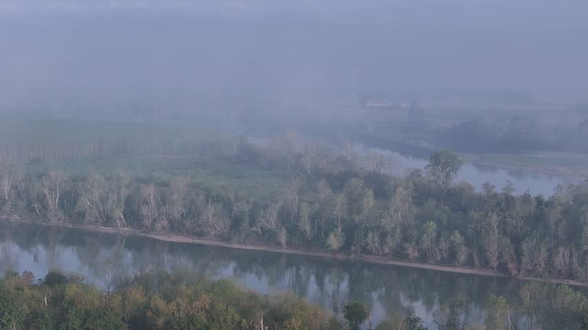 Isola Serafini along the Po River shows foggy water, wooded banks, riparian vegetation and low river islands near Monticelli d