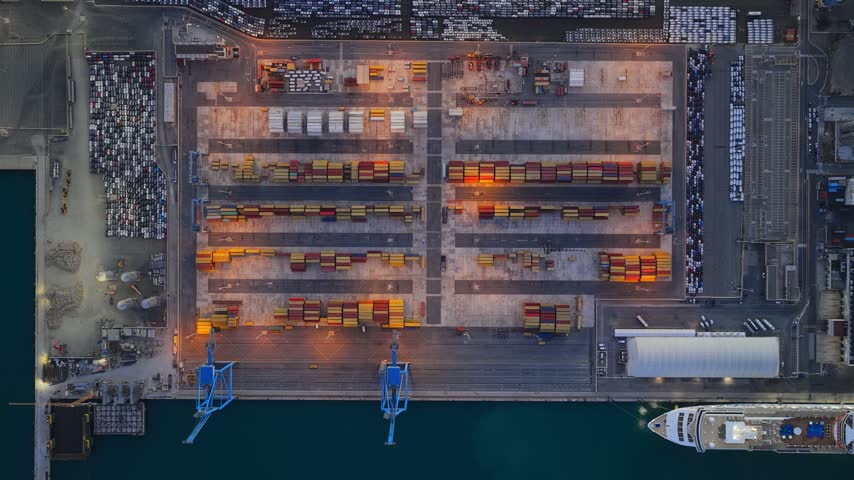 Aerial view of the Civitavecchia Port featuring rows of shipping containers and a cruise ship docked at the pier in Civitavecchia, Lazio, Italy.