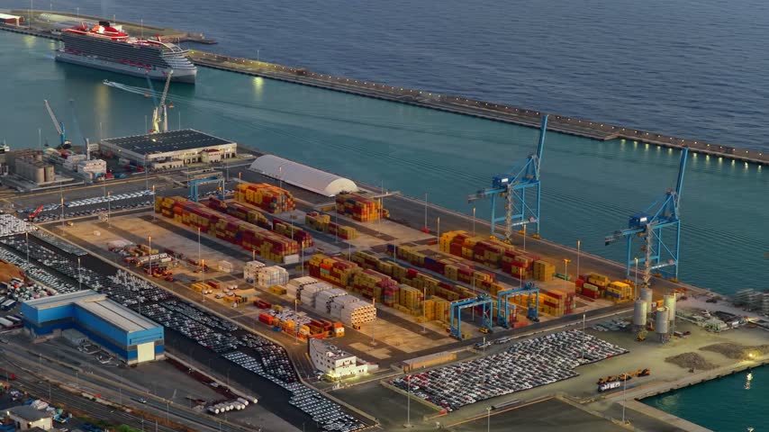 Aerial view of Civitavecchia Port with shipping containers, cranes, and a cruise ship docked at the harbor in Civitavecchia, Lazio, Italy.