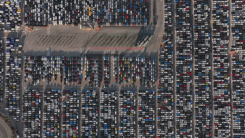 Aerial view of thousands of new cars parked in rows at the Civitavecchia Port automotive terminal in Civitavecchia, Lazio, Italy.