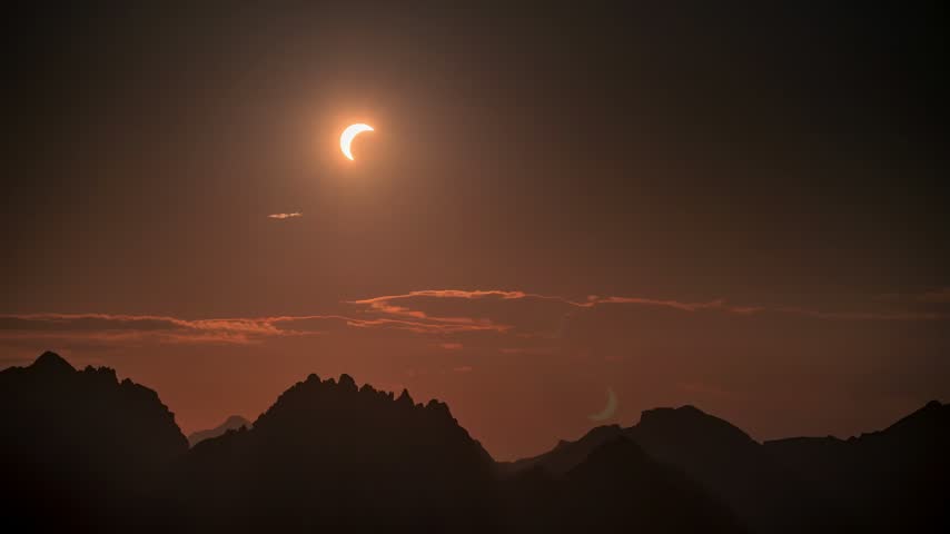 Partial Solar Eclipse Over Mountain Range at Dusk