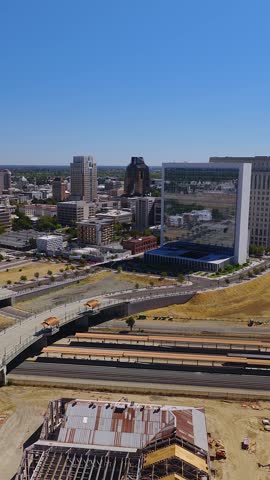Aerial view over the Sacramento Valley Station railyards and 5th Street bridge towards the modern downtown skyline and courthouse in Sacramento, California.