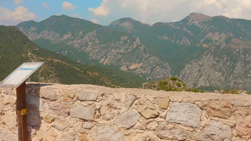 A scenic viewpoint overlooking the Alpes-Maritimes, or Alps of the Sea, in southern France, with rugged mountains, green hills and the surrounding landscape visible