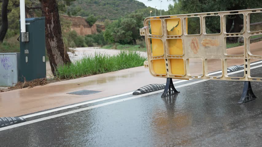 Turbulent muddy water overflowing from a riverbed during a dangerous flash flood event