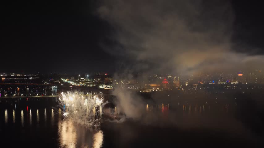 Holiday fireworks above water with reflection on the black sky background.