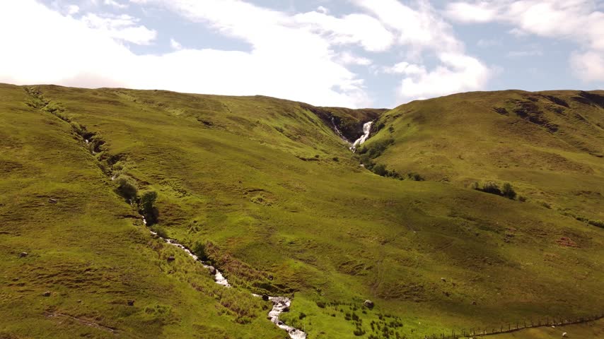 Cinematic 4K View of Dramatic Waterfall Cascading Through Rugged Landscape on Isle of Skye Scotland