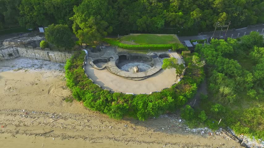 Aerial footage shows circular stone gun emplacement surrounded by woodland. Location: Weiyuan Fort, Dongguan, Guangdong, China. In daylight, the view records the visible setting and subject details.