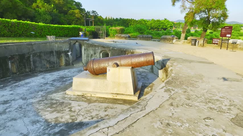 Aerial footage shows historic cannon inside an open stone gun emplacement. Location: Weiyuan Fort, Dongguan, Guangdong, China. In daylight, the view records the visible setting and subject details.