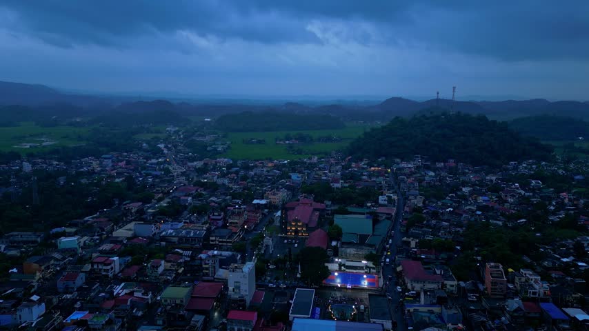 Cinematic aerial view of Buhi town and Lake Buhi during blue hour in Camarines Sur, Philippines. The footage features the urban and lakeside areas around San Benito, San Pascual and Santa Cruz, with M