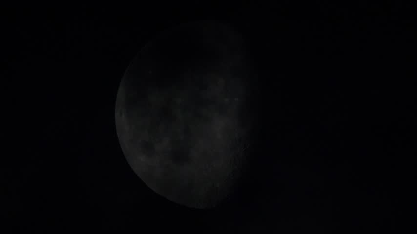 Footage of the full moon moving through the clouds at night.
