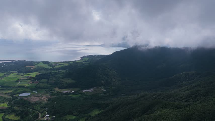 Mount Omoto near Torinji Town on Ishigaki Island, Okinawa, Japan, showing the forested mountain landscape and surrounding natural terrain - drone shot
