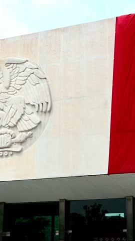National coat of arms of mexico carved on the stone facade of a government building