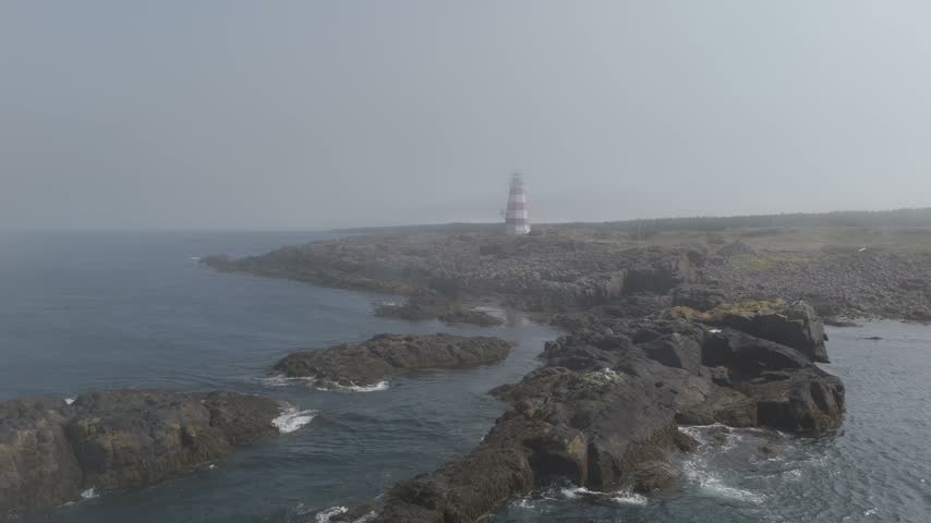 Witness stunning aerial perspectives showcasing the iconic lighthouses of Nova Scotia, Canada, perched on rugged cliffs by the ocean near Digby.