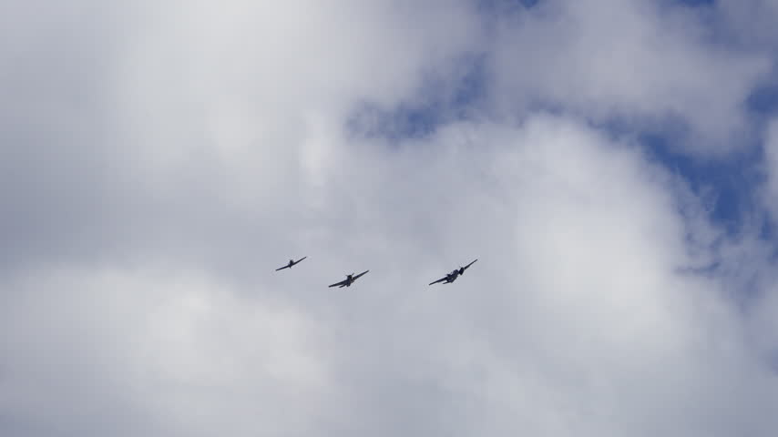 View of three planes flying alongside each other in the sky in slow motion.