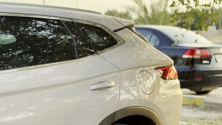 A close-up of a silver SUV parked in an outdoor lot during golden hour. The vehicle