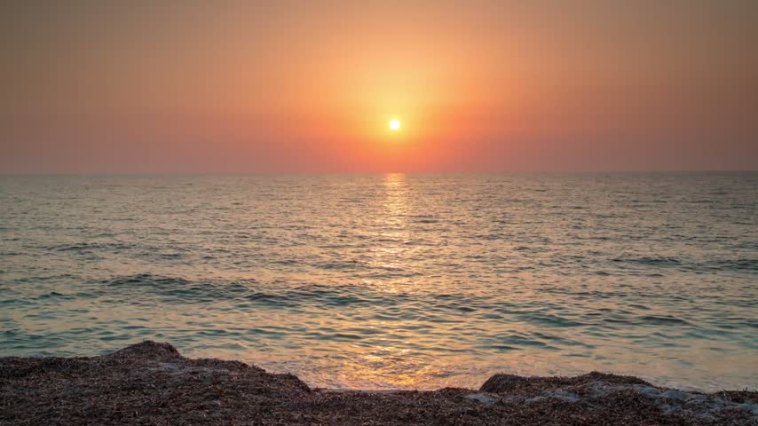 Sunset Over Ocean at Dusk with Rocky Shoreline