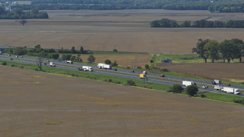 Drone aerial wide view and landscape establishing shot of countryside rural Ohio outside Columbus, OH by London as midwestern state with cornfields, farm land, huge fields, roads, highway, and trees