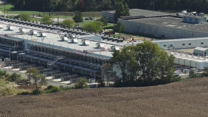 Drone aerial establishing view of large white data center construction being built in central Ohio by Springfield, OH near countryside rural country landscape of tech data building for AI hardware 4k