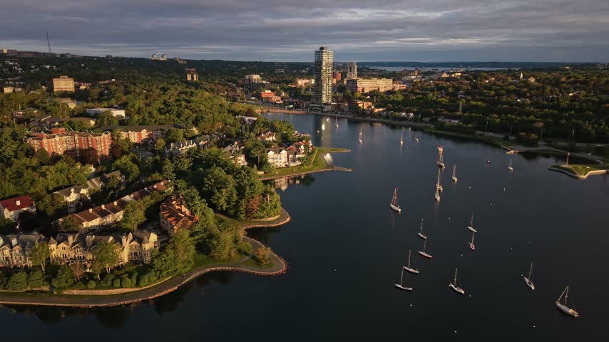 Experience the stunning aerial perspective of Halifax, Canada, with its serene waterways, lush greenery, and charming residential areas bathed in warm light.