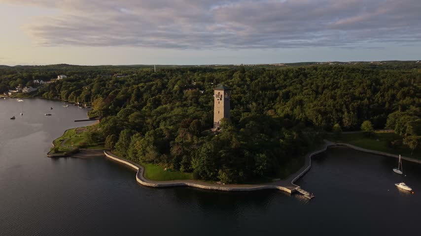 Experience stunning aerial perspectives of Halifax, Canada, highlighting lush greenery, serene waters, and a prominent historic tower against a tranquil sky.