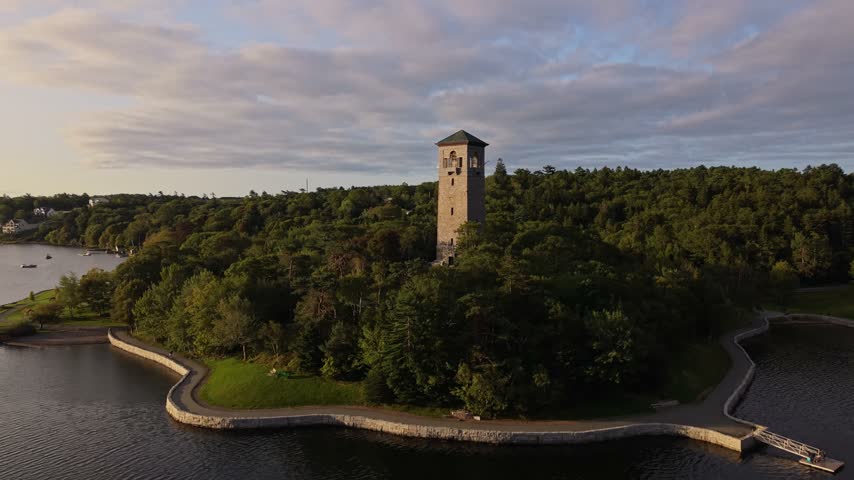 Explore the stunning landscapes of Halifax, Canada, highlighted by lush greenery and a historic watchtower overlooking the serene waters.