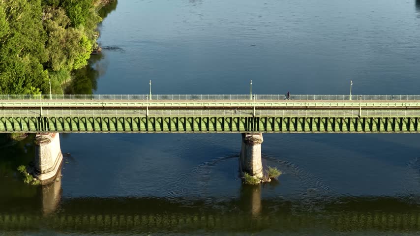Aerial footage of the iconic Pont Canal de Briare, a historic aqueduct bridge crossing the Loire River in Briare, France. The video captures the green metal structure of the aqueduct with its stone
