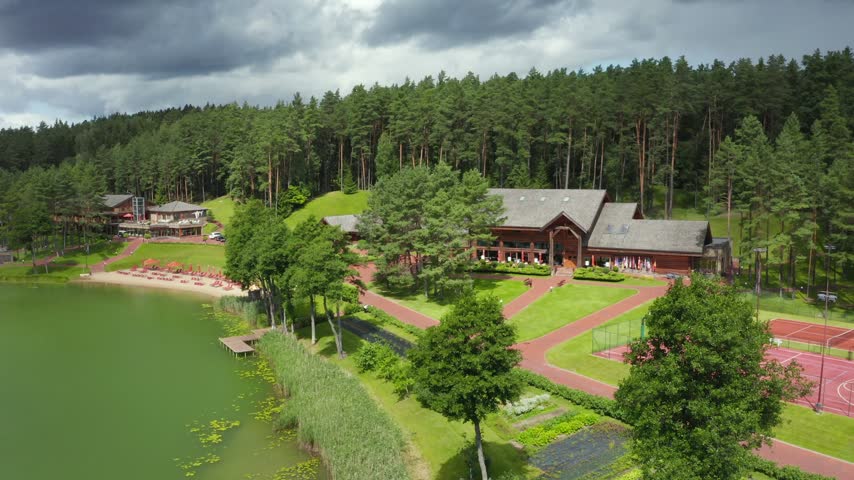 Aerial View of a Lakeside Luxury Resort and Wooden Cabins in a Forest