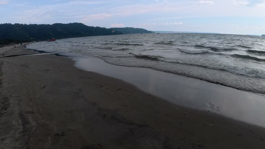 Wide sandy beach shoreline with gentle ocean waves