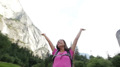 Happy free woman hiker dancing joyful in Yosemite National Park. Girl hiking dancing around in cheerful freedom pose elated and full of happiness during hike trek wearing backpack.