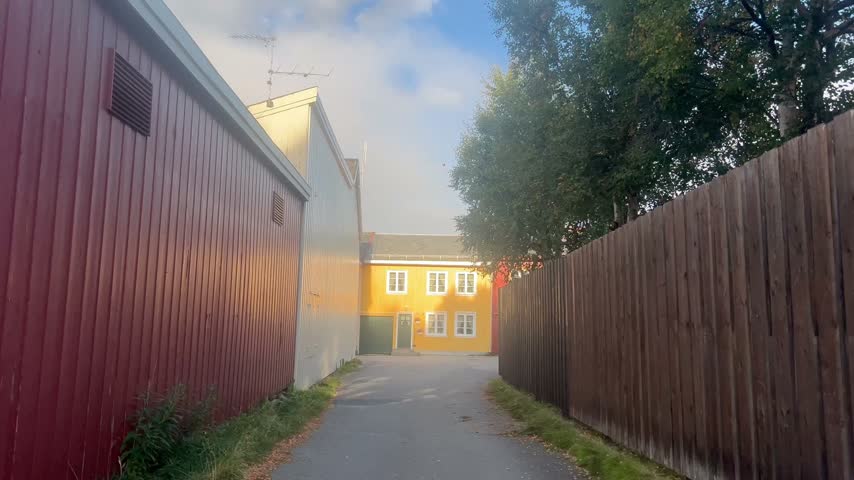 Yellow house standing at the end of a quiet rural alleyway.