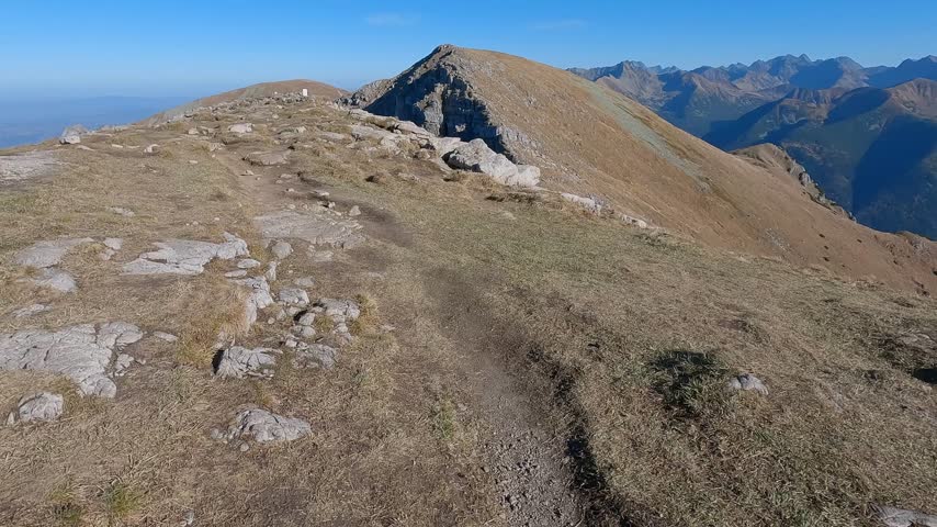 Rocky outcrop breaks an open grassy ridge on the high approach to Ciemniak