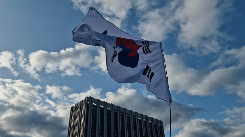 South Korean National Flag Waving Under Sky and Downtown Building in Seoul, South Korea