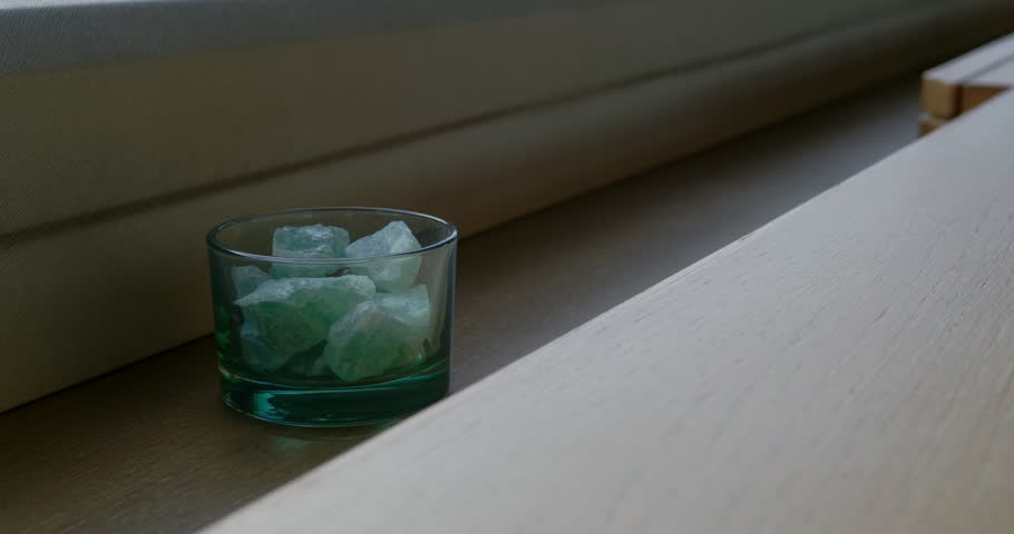 Slow zoom in on a glass with some rocks in.