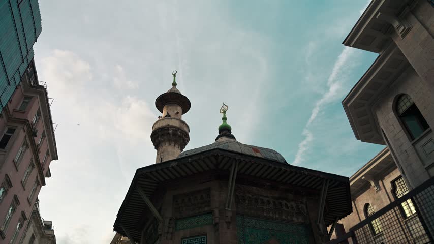 Low-angle view of historic Ottoman architecture with decorative tilework and a minaret in Istanbul, Turkey
