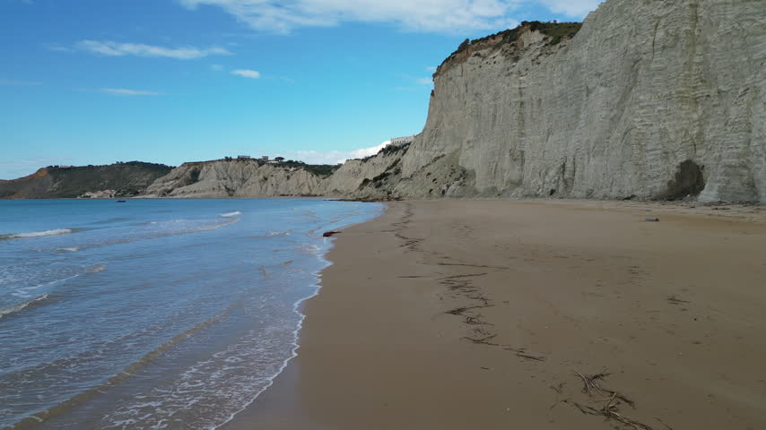 Low angle drone flight over secluded beach in front of 
