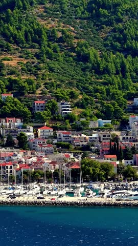 Croatia, aerial view of a coastal town with marina, boats, and hills