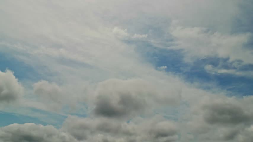 Thick white clouds drift across a bright prairie sky above