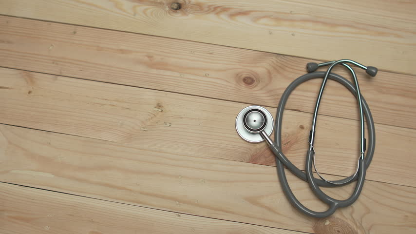 Medical stethoscope on a wooden table with copy space, representing healthcare, medicine, doctor equipment, medical examination, clinical care, and health services.
