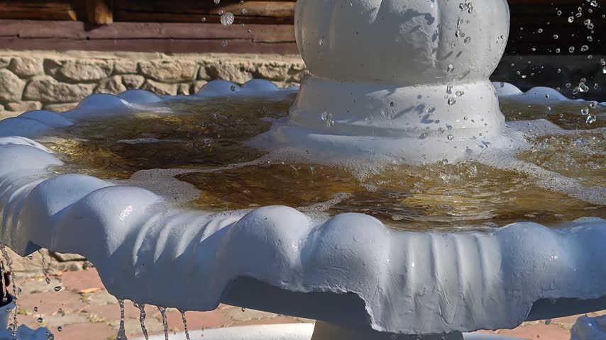 Close-up of an old white fountain in the middle of the park.