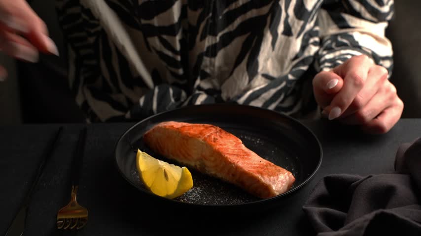 Fried salmon fillet on a plate. Drizzled with lemon juice.