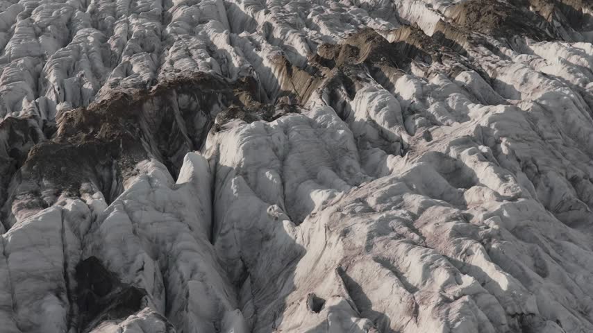 Aerial view of Aletsch Glacier with deep crevasses and rugged ice formations in Fieschertal, Valais, Switzerland.
