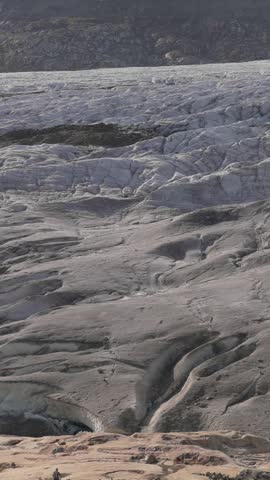Aerial view of the vast Aletsch Glacier with deep crevasses and rugged ice formations in the Swiss Alps near Fieschertal, Valais, Switzerland.