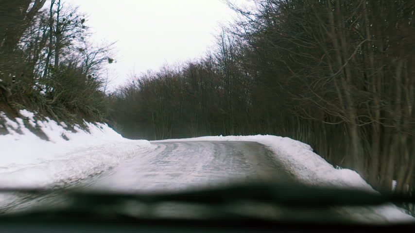 POV Car Driving on Winding Road with Snow in Winter Forest Near Ushuaia - 4K