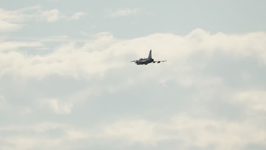 Swedish Air Force Saab JAS 39 Gripen multirole combat aircraft flying away at high altitude above the clouds during an aerobatic show