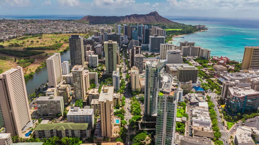 Aerial view of the Honolulu skyline with skyscrapers, urban streets, and the iconic Diamond Head volcanic crater in the background, Honolulu, Hawaii, United States.