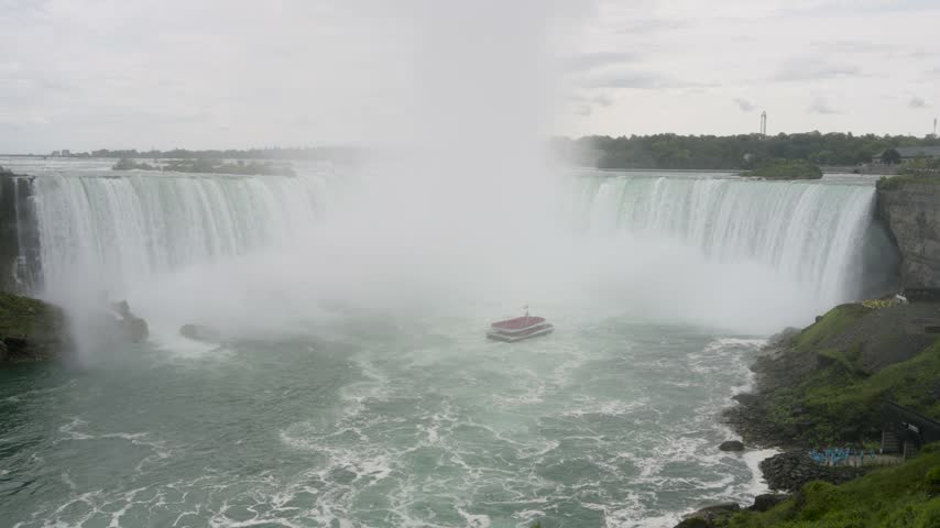 Tour boat approaching Horseshoe Falls through a wall of mist